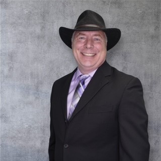 James Sader wearing a black suit and black cowboy hat.